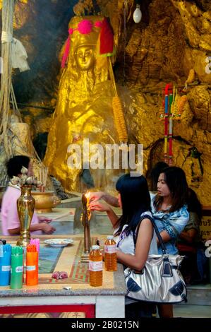 Thaïlande : les visiteurs de Bangkok éclairent de l'encens dans les grottes du sanctuaire du temple chinois San Chao Paw Khao Yai, Ko Sichang, province de Chonburi. Mystère entoure ce temple chinois coloré à plusieurs niveaux avec certains historiens disant qu'il remonte à la dynastie chinoise Ming (1368-1644). Il est communément admis qu'un sanctuaire a été fondé sur ce site par des marins chinois après qu'ils ont repéré une lumière réfléchie d'une grotte, qu'ils ont utilisé comme phare de fortune pour la navigation. Le temple a été construit quelque temps plus tard, principalement à l'usage des pèlerins chinois. Banque D'Images