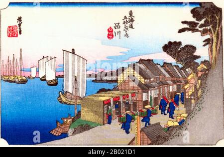 Japon : 'Station One : Daybreak at Shinagawa'. Estampe sur bois ukiyo-e de la série 'cinquante-trois stations de la route de Tôkaidô' par Utagawa Hiroshige (1797-1858), vers 1834. Shinagawa : une rue de maisons reposant sur le bord de mer, et la queue de la procession d'un daimyo passant le long de celle-ci ; derrière les maisons des navires amarrés dans la baie. Étant la première station sur l'autoroute, Shinagawa a été battue de voyageurs qui allaient et venaient. La route était bordée de nombreux salons de thé, restaurants et quartiers de divertissement. Banque D'Images