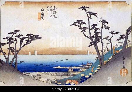 Japon : 'Station trente-deux : Shirasuka Pass'. Estampe sur bois ukiyo-e de la série 'cinquante-trois stations de la route de Tôkaidô' par Utagawa Hiroshige (1797-1858), vers 1834. Shirasuka : vue sur la mer à travers un plongeon dans la colline, au pied de laquelle passe la procession d'un daimyo ; des touffes d'arbres à droite et à gauche. La vue sur le paysage marin depuis Shiomizaka Slope près de cette station était l'une des plus pittoresques de toutes les cinquante-trois stations, avec l'océan Pacifique bleu encadré par des branches de pins. Une longue procession d'un seigneur féodal descend la colline vers la gare de Shirasuka. Banque D'Images