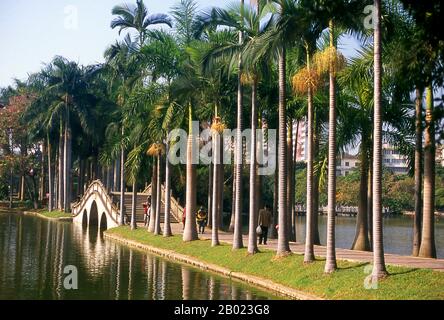 Chine : des palmiers bordent un chemin menant à un pont, Renmin Park, Nanning, province du Guangxi. Nanning a été fondée à l'origine sous la dynastie Yuan (1271-1368), bien qu'il y ait un siège de comté ici appelé Jinxing dès 318 EC. Ouvert au commerce extérieur par les Chinois en 1907, Nanning se développe rapidement. De 1912 à 1936, elle fut la capitale provinciale du Guangxi, en remplacement de Guilin. En raison de sa proximité avec la frontière vietnamienne, Nanning est devenu un centre majeur pour approvisionner le Nord-Vietnam de Hô Chi Minh pendant la seconde guerre d'Indochine (guerre du Vietnam). Banque D'Images