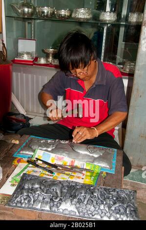 Le vieux quartier des silversmitths, centré sur Baan Wua Lai (Village de Potated Cow), s'étend le long des deux côtés de la route de Wua Lai, au sud de la vieille ville de Chiang Mai. Cette communauté d’artisans, bien établie et prospère, conserve une tradition qui remonte à plus de deux siècles, jusqu’au rétablissement de Chao Kawila à Chiang Mai dans les années qui ont suivi 1797. Les silversmitths ont longtemps été appréciés et tenus en haute estime par les tribunaux royaux d'Asie du Sud-est de Birmanie à Java, et dans les temps passé le Royaume Lan Na n'a pas été une exception. Banque D'Images