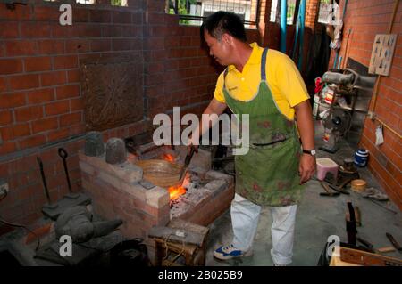 Le vieux quartier des silversmitths, centré sur Baan Wua Lai (Village de Potated Cow), s'étend le long des deux côtés de la route de Wua Lai, au sud de la vieille ville de Chiang Mai. Cette communauté d’artisans, bien établie et prospère, conserve une tradition qui remonte à plus de deux siècles, jusqu’au rétablissement de Chao Kawila à Chiang Mai dans les années qui ont suivi 1797. Les silversmitths ont longtemps été appréciés et tenus en haute estime par les tribunaux royaux d'Asie du Sud-est de Birmanie à Java, et dans les temps passé le Royaume Lan Na n'a pas été une exception. Banque D'Images