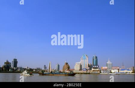 Chine : trafic commercial sur la rivière Huangpu (en regardant vers Suzhou Creek), Shanghai, 2000. Shanghai a commencé sa vie comme un village de pêcheurs, et plus tard comme un port recevant des marchandises transportées sur le fleuve Yangzi. À partir de 1842, au lendemain de la première guerre de l’opium, les Britanniques ont ouvert une « concession » à Shanghai où les trafiquants de drogue et autres commerçants pouvaient opérer sans être dérangés. Les Français, les Italiens, les Allemands, les Américains et les Japonais ont tous suivi. Dans les années 1920 et 1930, Shanghai était une ville florissante et un synonyme international de dissipation. Banque D'Images