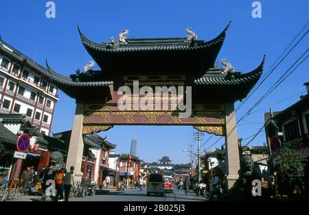 Chine : une passerelle de paifang élaborée menant à Fangbang lu avec la Tour Jin Mao en arrière-plan (Pudong), Nanshi ou la vieille ville, Shanghai. Shanghai a commencé la vie comme un village de pêcheurs, et plus tard comme un port recevant des marchandises transportées le long du fleuve Yangzi. À partir de 1842, à la suite de la première guerre de l'opium, les Britanniques ont ouvert une « concession » à Shanghai où les trafiquants de drogue et d'autres commerçants pouvaient fonctionner sans être dérangés. Les Français, les Italiens, les Allemands, les Américains et les Japonais ont tous suivi. Dans les années 1920 et 1930, Shanghai était une ville en plein essor et un mot international pour la dissipation. Banque D'Images