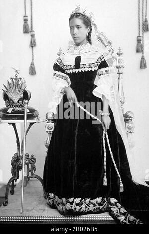 Madagascar : Reine Ranavalona III (22 novembre 1861 - 23 mai 1917) avec couronne royale et sceptre. Photographié à Antananarivo, v. 1890-1895. Ranavalona III fut le dernier souverain du Royaume de Madagascar. Elle règne du 30 juillet 1883 au 28 février 1897, dans un règne marqué par des efforts continus et finalement futiles pour résister aux desseins coloniaux du gouvernement français. En tant que jeune femme, elle a été sélectionnée parmi plusieurs andriana (nobles) qualifiés pour succéder à la reine Ranavalona II à sa mort. Banque D'Images