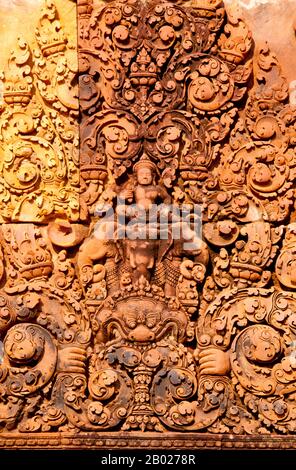Cambodge : Indra monte l'Airavata à trois têtes au-dessus du démon Kala sur un linteau au-dessus de la porte d'entrée de Banteay Srei (Citadelle des femmes), Angkor. Banteay Srei (ou Banteay Srey) est un temple cambodgien du 10ème siècle dédié au Dieu hindou Shiva et est situé au nord-est du groupe principal de temples à Angkor. Banteay Srei est construit en grande partie en grès rouge, un médium qui se prête aux sculptures murales décoratives élaborées qui sont encore observables aujourd'hui. Banteay Srei est parfois appelé le « joyau des Khmers remplacés » Banque D'Images