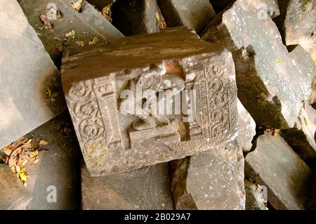 Cambodge : moitié inférieure de Shiva dansante, Beng Mealea (temple khmer du XIIe siècle), à 40 km à l'est du groupe principal de temples à Angkor. Beng Mealea a été construit comme un temple hindou, mais il y a quelques sculptures représentant des motifs bouddhistes. Son matériau primaire est le grès et il est en grande partie non restauré, avec des arbres et des broussailles épaisses prospérant au milieu de ses tours et cours et beaucoup de ses pierres se trouvant dans de grands tas. Pendant des années, il était difficile d'atteindre, mais une route récemment construite pour le complexe du temple de Koh Ker passe Beng Mealea et plus de visiteurs viennent sur le site. Banque D'Images