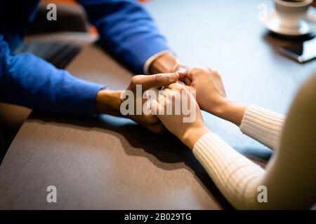 Gros plan sur les jeunes couples multiethniques qui tiennent les mains Banque D'Images