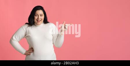 Femme De Plump Excité Pointant De Côté À L'Espace De Copie Sur Fond Rose Banque D'Images