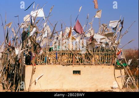 Chine : un tombeau dans les dunes de sable près de l'Imam Asim Mazar (sanctuaire) dans le désert près de Khotan, province du Xinjiang. Le sanctuaire de l'Imam Asim et d'autres tombes se trouvent à 23 kilomètres de Khotan (Hotan) sur la route de la soie au sud. C'est le site d'un immense pèlerinage chaque mois de mai. L’Imam Asim a été l’un des premiers missionnaires islamiques à visiter cette région. Khotan retrace son histoire au moins aussi loin que le IIIe siècle av. J.-C., lorsque le fils aîné de l'empereur indien Asoka s'est installé ici. C'était d'une grande importance sur la route de la soie. Banque D'Images