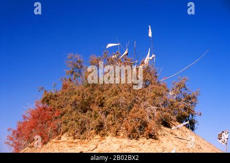 Chine : un tombeau dans les dunes de sable près de l'Imam Asim Mazar (sanctuaire) dans le désert près de Khotan, province du Xinjiang. Le sanctuaire de l'Imam Asim et d'autres tombes se trouvent à 23 kilomètres de Khotan (Hotan) sur la route de la soie au sud. C'est le site d'un immense pèlerinage chaque mois de mai. L’Imam Asim a été l’un des premiers missionnaires islamiques à visiter cette région. Khotan retrace son histoire au moins aussi loin que le IIIe siècle av. J.-C., lorsque le fils aîné de l'empereur indien Asoka s'est installé ici. C'était d'une grande importance sur la route de la soie. Banque D'Images