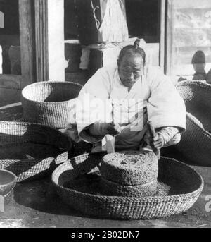 Corée : moudre des haricots dans une rue de Séoul, 1901. Séoul est la capitale et la plus grande métropole de la Corée du Sud. Mégapole avec une population de plus de 10 millions d'habitants, c'est la plus grande ville proprement dite du monde développé. La région de la capitale de Séoul, qui comprend la métropole environnante d'Incheon et la province de Gyeonggi, est la deuxième plus grande région métropolitaine du monde avec plus de 25,6 millions d'habitants, qui abrite plus de la moitié des Sud-Coréens et 632 000 résidents internationaux. Banque D'Images