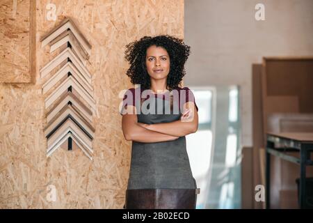 Jeune entrepreneur confiant debout dans son atelier de cadrage Banque D'Images