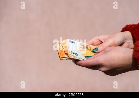 Participation à la main montrant de l'argent en euros et donnant ou recevant de l'argent comme des bouts, salaire. 50 billets EN EUROS monnaie en euros isolée. Concept de peo d'entreprise riche Banque D'Images