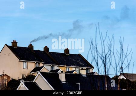 La fumée de la combustion de combustibles fossiles souffle dans le ciel à Ardara, comté de Donegal, Irlande Banque D'Images