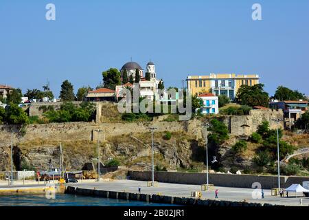 Kavala, Grèce - 18 septembre 2015 : personnes non identifiées sur le quai, église Kimissis Theotokou, bâtiment scolaire et maisons sur la péninsule de Panagia dans le c Banque D'Images