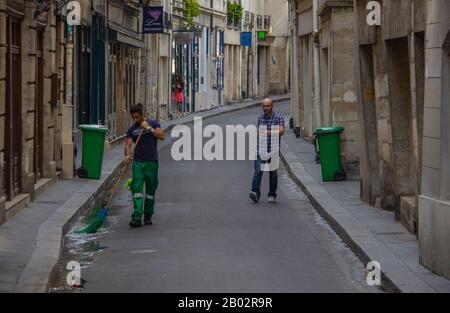 Balayant une rue, Paris Banque D'Images
