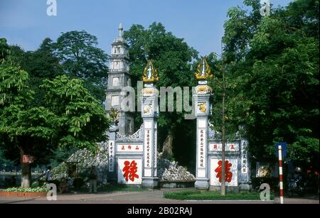 Den Ngoc son, ou Temple de la montagne de Jade, est l'un des complexes religieux les plus vénérés de la capitale. Établi par le scientifique mandarin Nguyen Van Sieu (1799–1872), les symboles appropriés de l'apprentissage et de la littérature marquent le complexe du temple. Une bande stylisée d'encre de pierre repose sur la porte arquée à l'entrée ; à proximité, un pilier en pierre représentant un stylo à brosse chinois traditionnel s'élève sur cinq niveaux. De son côté, trois idéogrammes chinois proclament ta thanh thien, ou «écrire sur un ciel clair». Au-delà de l'entrée, un pont en bois peint en rouge avec élégance mène à travers le Still gre Banque D'Images