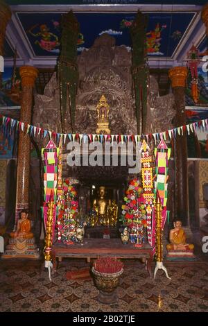 Le temple ce du Wat Nokor Bayon de Kompong Cham était à l'origine un sanctuaire bouddhiste de Mahayana. Il a été dédié au bouddhisme Theravada, la principale tradition religieuse du Cambodge, à un moment donné au XVe siècle. Les vénérables structures de grès et de latérie de l'ancien temple se mêlent bien avec un temple moderne actif, des moines ocre et le son du chant, créant un mélange fascinant du contemporain et de l'archaïque. Il y a plusieurs anciennes images de Bouddha, et un grand Bouddha inclinable plus moderne. Banque D'Images