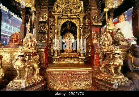 Le Hiranyavarna Mahavihara, ou Temple d'Or, est l'un des plus grands spectacles d'art et d'architecture de la vallée de Katmandou. Soi-disant fondé au 12th siècle par le roi Bhaskara Deva Varma, le temple, tel qu'il se présente aujourd'hui, remonte pour la plupart au 18th siècle. Toute la façade du sanctuaire principal est recouverte de cuivre doré, tout comme la torana très détaillée et tous les toits. Banque D'Images