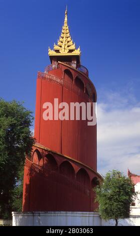 Le château du fort Mandalay, à près de 3 km (3 miles) de murs, abrite le palais du roi Mindon. Les murs s'élèvent à 8 m (26 pi). Le palais a été construit entre 1857 et 1859 dans le cadre de la fondation par le roi Mindon de la nouvelle capitale royale de Mandalay. Le plan du palais de Mandalay suit en grande partie la conception traditionnelle du palais birman, à l'intérieur d'un fort fortifié entouré d'une lune. Le palais lui-même est au centre de la citadelle et fait face à l'est. Tous les bâtiments du palais sont d'une histoire en hauteur. Le nombre de spires au-dessus d'un bâtiment a indiqué l'importance de la zone ci-dessous. Mandalay, une ville tentaculaire de plus de th Banque D'Images