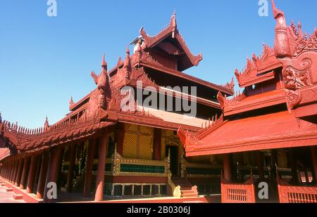 Le château du fort Mandalay, à près de 3 km (3 miles) de murs, abrite le palais du roi Mindon. Les murs s'élèvent à 8 m (26 pi). Le palais a été construit entre 1857 et 1859 dans le cadre de la fondation par le roi Mindon de la nouvelle capitale royale de Mandalay. Le plan du palais de Mandalay suit en grande partie la conception traditionnelle du palais birman, à l'intérieur d'un fort fortifié entouré d'une lune. Le palais lui-même est au centre de la citadelle et fait face à l'est. Tous les bâtiments du palais sont d'une histoire en hauteur. Le nombre de spires au-dessus d'un bâtiment a indiqué l'importance de la zone ci-dessous. Mandalay, une ville tentaculaire de plus de th Banque D'Images