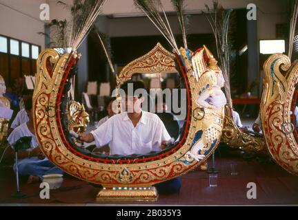 Thaïlande : un jeune homme joue du khong mon, un instrument de cercle de gong, dans un orchestre thaïlandais traditionnel, Bangkok. Le khong mon est un instrument de cercle de gong associé au peuple mon de l'Asie du Sud-est continentale. Il produit la même gamme d'emplacements que le cercle khong wong gong plus commun, mais plutôt que de reposer sur le sol, le cadre en bois du khong mon s'étend dans les airs en forme de fer à cheval. L'image d'un demi-homme, d'un demi-oiseau sculpté sur le cadre est traditionnelle et est censée symboliser un musicien céleste. Banque D'Images