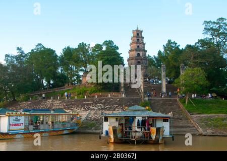 La pagode Thien Mu vue d'un bateau-dragon sur la rivière des parfums. La pagode Thien Mu a été construite en 1601 EC sous Nguyen Hoang, le gouverneur de la province de Thuan Hoa, maintenant connue sous le nom de Hue. Bien qu'il ait juré fidélité à la dynastie le à Hanoi, Nguyen Hoang dirigea effectivement Thuan Hoa en tant qu'État indépendant dans le centre du Vietnam. La pagode a sept étages et est la plus haute du Vietnam, et est souvent le sujet de rimes folkloriques et de poésie sur Hué, qui était la capitale impériale du Vietnam entre 1802 et 1945. Banque D'Images