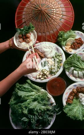 NEM nướng peut être mangé seul comme apéritif ou en-cas, et plongé dans Nước chấm (sauce trempée), ou avec une sauce aux arachides. Nước chấm est une sauce au poisson diluée à l'eau et aromatisée au sucre, au jus de citron vert, à l'ail brut haché, au piment frais haché pour les oiseaux (piment thaïlandais)/poivre de Cayenne, et parfois au vinaigre. La sauce aux arachides est faite de beurre d'arachide et de sauce au hoisin, aromatisée à la sauce au poisson et à l'ail écrasé, surmontée d'arachides grillées écrasées. Il est servi avec des légumes frais tels que la laitue, les légumes marinés julientés comme les carottes et les radis blancs, et les herbes fraîches comme la menthe et le basilic. Banque D'Images