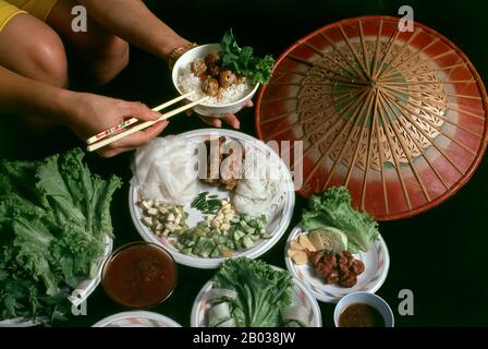 NEM nướng peut être mangé seul comme apéritif ou en-cas, et plongé dans Nước chấm (sauce trempée), ou avec une sauce aux arachides. Nước chấm est une sauce au poisson diluée à l'eau et aromatisée au sucre, au jus de citron vert, à l'ail brut haché, au piment frais haché pour les oiseaux (piment thaïlandais)/poivre de Cayenne, et parfois au vinaigre. La sauce aux arachides est faite de beurre d'arachide et de sauce au hoisin, aromatisée à la sauce au poisson et à l'ail écrasé, surmontée d'arachides grillées écrasées. Il est servi avec des légumes frais tels que la laitue, les légumes marinés julientés comme les carottes et les radis blancs, et les herbes fraîches comme la menthe et le basilic. Banque D'Images