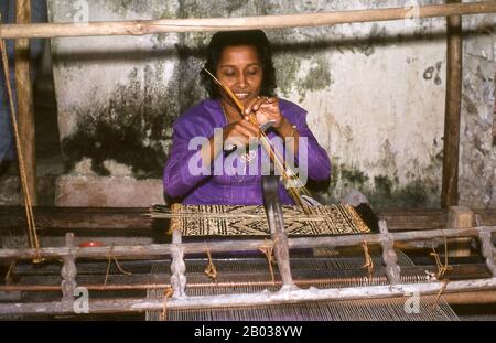 Kunaa tissage est une occupation exclusivement féminine. Les femmes de Gadu traversent régulièrement vers l'île voisine de Gan où elles récoltent une herbe particulièrement résiliente connue sous le nom de hau. Il est ensuite coloré avec une variété de colorants naturels avant d'être tissé dans des conceptions traditionnelles sur un métier simple. Les conceptions sont traditionnelles, remises de la mère à la fille de génération en génération. Au milieu du XVIIe siècle si prisé si Gadu kunaa était devenu dans la région voisine de l'océan Indien qu'ils ont été envoyés dans le cadre de l'hommage annuel du sultan maldivien au Royaume de Sri Lanka. Banque D'Images