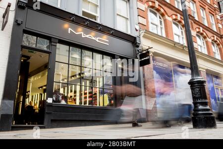 Magasin Mac, Covent Garden, Londres. Exposition longue, les clients flous marchant devant le magasin de cosmétiques de haute rue, Mac. Banque D'Images