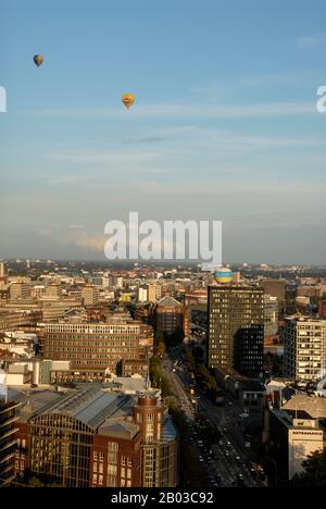 Une paire de ballons d'air chaud qui dérivent au-dessus de Hambourg en Allemagne en fin d'après-midi, près du toit en cuivre vert du Hamburger Rathaus (Hamburg Ci Banque D'Images