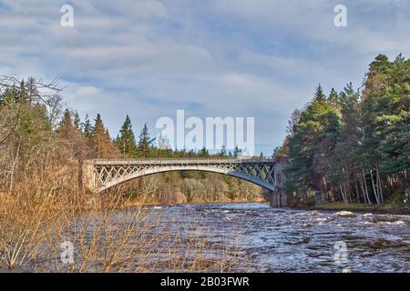 VILLAGE DE CARRON MORAY ECOSSE VUE DE LA RIVE DE LA RIVIÈRE À LA ROUTE UNIQUE DE CARRON ET VIEUX PONT FERROVIAIRE QUI TRAVERSE LA RIVIÈRE SPEY Banque D'Images