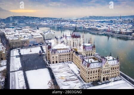 Budapest, Hongrie - vue aérienne du Parlement enneigé de Hongrie avec le pont de la chaîne Szechenyi, le palais royal du château de Buda en arrière-plan et la chute de sno Banque D'Images