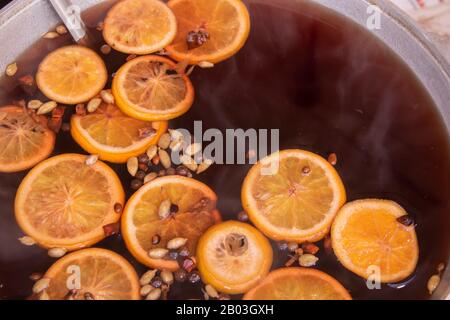 Grande casserole avec vin chaud haché oranges et épices rue nourriture fastival Banque D'Images