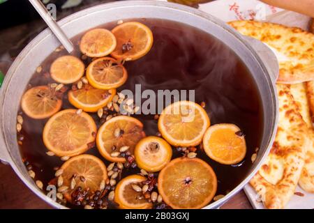 Grande casserole avec vin chaud haché oranges et épices rue nourriture fastival Banque D'Images