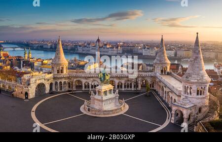 Budapest, Hongrie - le célèbre bastion des pêcheurs au lever du soleil avec la statue du roi Stephen I et du Parlement hongrois en arrière-plan Banque D'Images