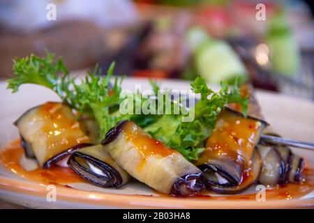 Aubergines cuites aux herbes épicées avec sauce douce aubergines farcies Rolls Plat Apéritif pour dîner de vacances gros plan macro Banque D'Images