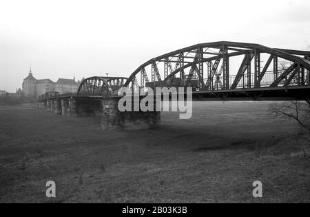 15 février 1990, Saxe, Torgau: Un lourd camion et un Trabant franchit le pont d'Elbe à Torgau au début des années 1990, avec le château de Hartenfels en arrière-plan. Date exacte de l'enregistrement inconnue. Photo : Volksmar Heinz/dpa-Zentralbild/ZB Banque D'Images