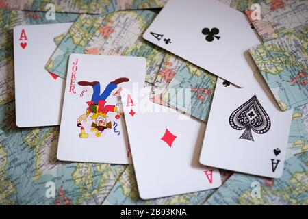 Quatre as et un Joker dans un paquet de cartes à jouer avec une carte de l'Europe au dos des cartes Banque D'Images