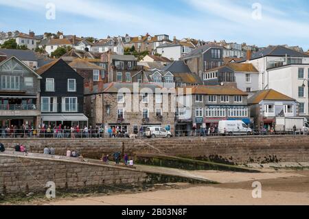 Vue sur Harbour Sand et une route de quai animée de West Pier à St Ives, Cornwall pendant la marée basse. Banque D'Images