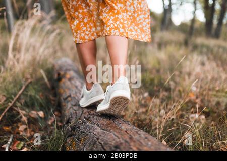 Jeune femme marchant dans la forêt portant des robes Banque D'Images