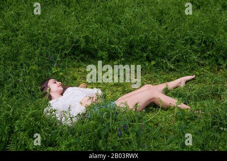 Une jeune femme dans un domaine de la vetch. Banque D'Images