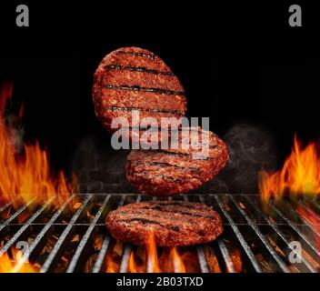 Des côtelettes de bœuf pour les hamburgers. Processus de préparation. Viande rôtie sur barbecue en métal barbecue grill avec feu flammant lumineux et charbon de bois de membre sur b Banque D'Images