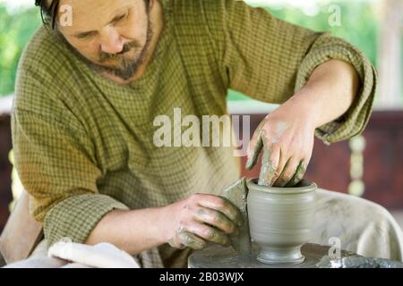 Potier traditionnel utilisant l'ancienne méthode dacienne sur une roue d'argile à pied au Musée du Village à Baia Mare, Maramureș, Roumanie Banque D'Images