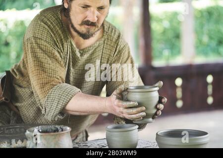 Potier traditionnel utilisant l'ancienne méthode dacienne sur une roue d'argile à pied au Musée du Village à Baia Mare, Maramureș, Roumanie Banque D'Images