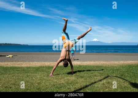 Un jeune homme s'est mis à danser sur la promenade du lac à Frutillar, une petite ville du lac Llanquihue dans le district du lac près de Puerto Montt, au Chili avec Osorno Banque D'Images