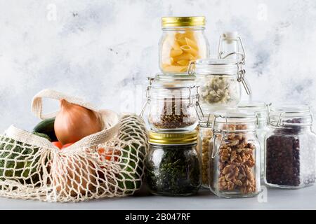 haricots, graines de lin, noix, lait, proue dans un bol en verre . nourriture saine dans des bocaux en verre, sac de shopping en maille avec légumes. Nourriture propre, végétalienne, zéro déchet, e Banque D'Images