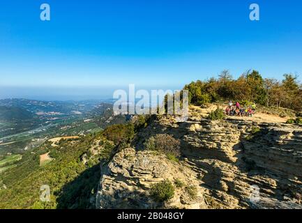 Emilie Romagne - un groupe de randonneurs repose sur le sommet du mont Adone, le point le plus élevé de la contreforte Pliocène. Dans le bassin de la vallée de Sasso Marconi et en arrière-plan de la vallée de po vers Bologne. Banque D'Images